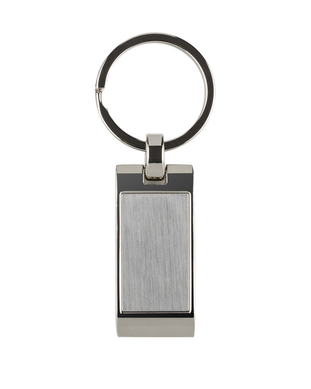 Metalni privjesak za ključeve s pravokutnim, valovitim privjeskom. Logo će biti ugraviran na površini privjeska.