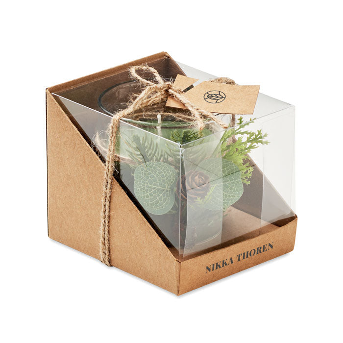 Stakleni svijećnjak (120 gr) sa šumskim aranžmanom. Isporučuje se u kartonskoj i PVC kutiji s užetom i kraft etiketom. Svijeća uključena.